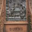View of panel showing 'The Cottar's Saturday Night', on the front of the pedestal of the Robert Burns statue.