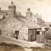 View of cottage in Holyrood Park from East, with woman sitting on window frame.
Titled: 'Jeannie Dean's Cottage, St. Leonards, Edinburgh.  1170.  G.W.W.'
Since demolished.