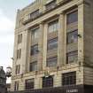 View of S facade of building, showing Royal Arms of Scotland above first floor window, and clock at corner.