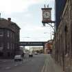 View of Fountain Brewery clock, attached to wall above war memorial.