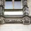 View of two half-figures, in frieze below dormer windows on N side of building.