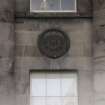 View of carved female head in roundel (one of four), above first floor window on facade of S side of Charlotte Square.