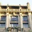 View of facade of 1923-25 extension, 3 St Andrew Square, showing term figures at top of building, and a female figure with horses in pediment above central second floor window.