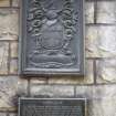 View of coat of arms and inscription panel on wall.