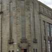 View of corner of Fountainbridge Library, showing carved relief above door and metal panels on windows.