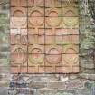 View of terracotta tile relief, on wall in small public garden in Campbell's Close.