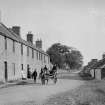 View of West Saltoun Main Street with horse and cart and people.