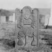 General view of gravestone, 1744,  with winged soul, sock and coulter and Adam and Eve.
