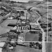 Robert Craig and Sons Ltd. Caldercruix Paper Mills, Airdrie Road, Caldercruix.  Oblique aerial photograph taken facing east.  This image has been produced from a crop marked negative.