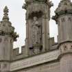 Detail of statue in niche of tower on N face .