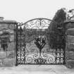 Historic photograph showing view of wrought iron gate.