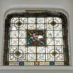 Interior, view of ground floor library stained glass window of a robin