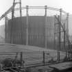 General view of new spiral guided gas holder uninflated, showing spiral stairway and erection mast, with Number 5 gas holder in background, Meadow Flat Gas Holder, Holyrood Road, Edinburgh, in 1933.
