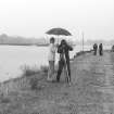 Tony Long filming operations in the rain on Craignure old pier, sheltered by a friend.