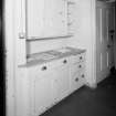 Interior.  Detail of fitted cupboards and drawers in Kitchen Pantry with hatch to kitcchen.