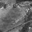 Oblique aerial view centred on the cropmarks of the enclosure, pit-alignment, linear cropmarks, pits and rig with standing stone adjacent, taken from the WNW.