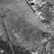 Oblique aerial view centred on the cropmarks of the enclosure, pit-alignment, linear cropmarks, pits and rig with standing stone adjacent, taken from the SSW.