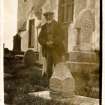 Scanned image of photograph of John Nicolson in graveyard beside headstones and church