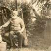 Photograph of John Nicolson and female in garden beside sculpted stones