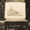 Photograph of painting which depicts a man sitting on rocks looking out to sea, by Lady Caithness, 1865.