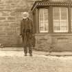 Scanned image of photograph of John Nicolson standing in front of Summerbank House, Auckengill