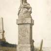 Scanned image of photograph of scuplture by John Nicolson of a boy seated on a pedestal in Canisbay Churchyard