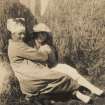 Scanned image of photograph of a male and female in the middle of haystacks