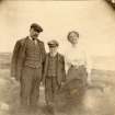 Scanned image of photograph of a male, female and male child all in formal attire standing in field