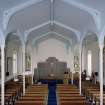 Interior. View from W from gallery showing the communion table and platform