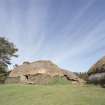 View of reconstructed thatched farmhouse with barn to rear