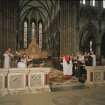 Interior.
View of choir and apse ended chancel with director of music conducting choristers.