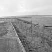 View from E of zig-zag perimeter fence to rear of torpedo stores.