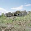 View from NE showing collapsed and standing asbestos roofed huts.