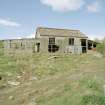 View fom E showing standing remains of asbestos roofed hut with timber extension.