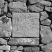Detail of stone in W wall of front garden inscribed "ENJA HUC VENIT UT CYCLOPS KAL. OCT. 1993"