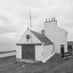 Detailed view from E of coastguard station, with houses behind