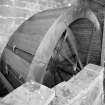 Interior view: detail of recently-restored iron-framed undershot water wheel (with wooden buckets)