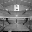 Interior. 
View from E showing raked seating, box pews and gallery.