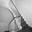 Interior. View of staircase at first floor landing showing cast iron balusters