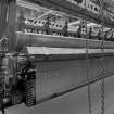 Interior.  Detailed view showing wire cloth emerging from a loom in the Broadloom Weaving Department