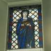 View of reused stained glass window depicting a lady to the East of the organ..