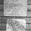 Photographic copy of two rubbings. The upper rubbing is of an unidentified panel, bearing the date 1677. The lower rubbing shows the double disc and Z-rod and beast's head Pictish symbol carvings in Doo Cave, East Wemyss.