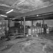 Alloa, Thistle Brewery, Basement floor, Cellar/Cask store, interior
View from SW showing construction, concrete floor, rubble walls from earlier 19th century phase, concrete/railway rail ceiling and later inserted steel beams. All the casks in this view are awaiting dispatch