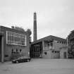 Alloa, Whins Road, Brewery
View from SE of brewhouse (with grist case no. 2 on roof, right), chimney and boiler house block. The bore hole housing is the flat roofed building on the right. The bore hole provides water for cooling the refrigeration compressors. The water for brewing is taken from the mains and is filtered through the Candy water filtration system on site