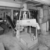 Alloa, Whins Road, Brewery, Mill Room area, top floor, interior
View showing intake and distribution area of mill room area. Note intake duct carrying malted barley mix from the fourth floor of the Barns Block c.120 metres away. The grain is conveyed to the Buhler destoner, in the foreground of the picture, which sorts out foreign bodies from the malt mix by vibrating at a rate of 4000 r.p.m. Any foreign bodies (metalwork, stones etc.) falls into a sack attached to the mouth of the destoner of which can be seen in the foreground. The malt to be milled is removed by means of a 'screw' visible in the middle foreground and conveyed to a screen below which feeds the Miag malt mill