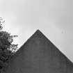 Detail of dated pediment at apex of W gable of church.