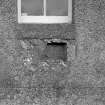 Reused socketed stone in external face of South wall of church, below window.
