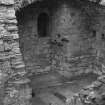 Excavation photograph : NE corner of tower house basement showing pit prison and chamber's floor partially excavated, from SW.