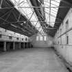 Interior view of the former wash house seen from the North, showing tiled walls and the structural metal supports of the roof.