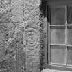 View of face of fragmented Pictish symbol stone, used as lintel above a window at East Balhalgardy Farm.